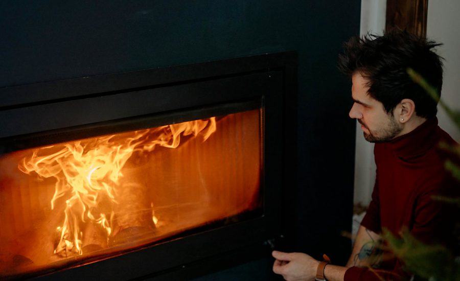 Homme devant un feu de cheminée